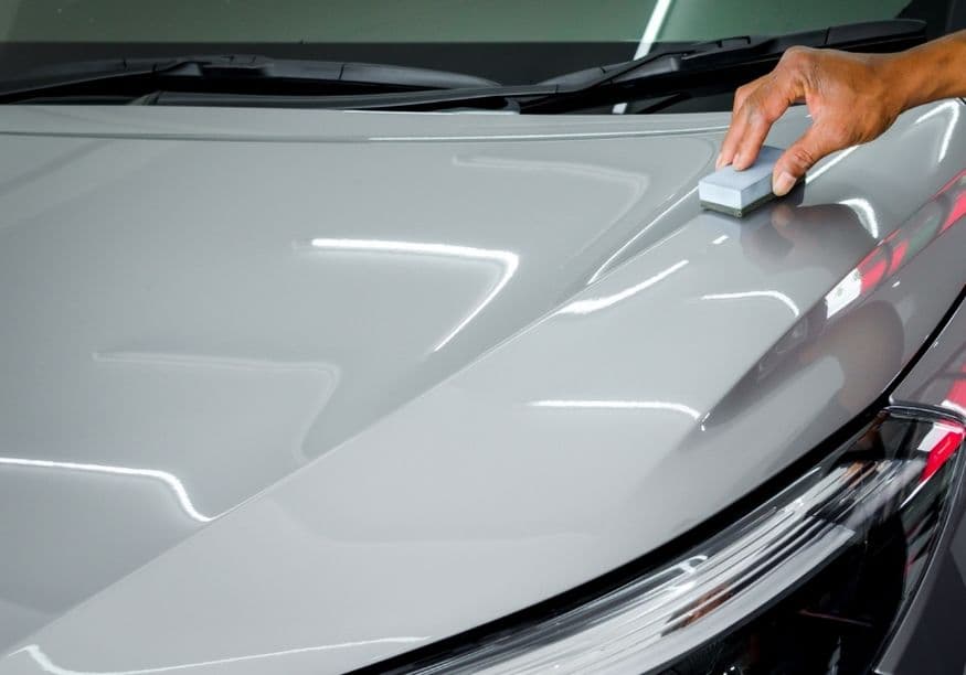 Applying paint protection with an applicator pad on a glossy hood — wax vs sealant application in Vancouver