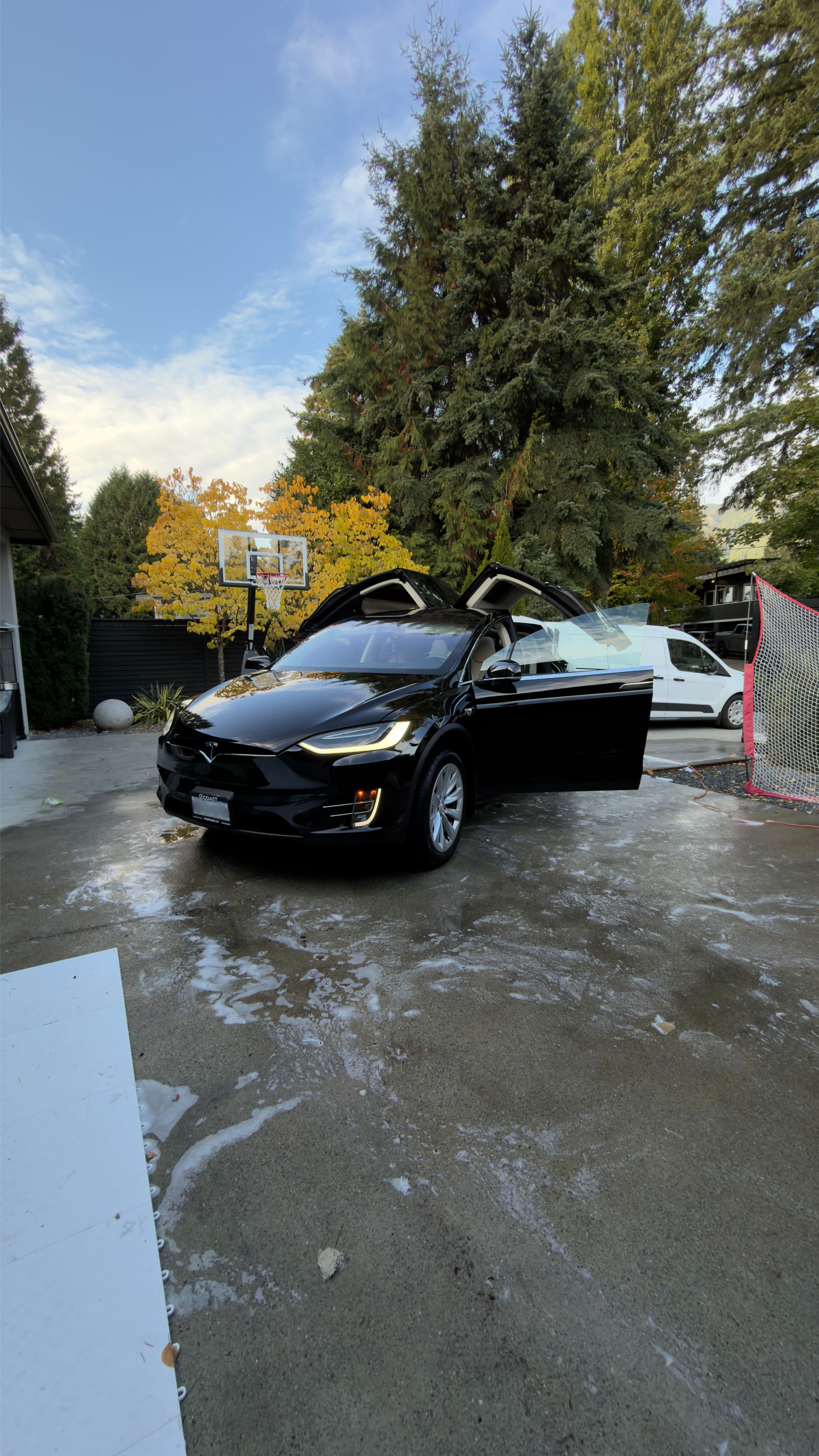 Black Tesla Model X during new car ceramic coating service at a Vancouver home driveway by Crystal Gloss