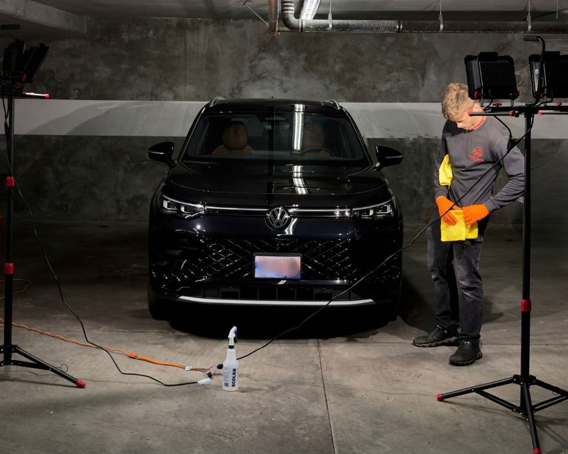 Crystal Gloss applying ceramic coating to a black VW ID.4 EV in a Vancouver condo parkade