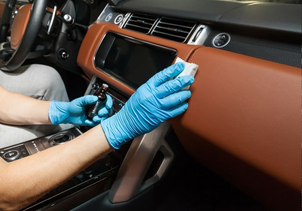 Technician applying ceramic leather coating to a leather dashboard — mobile leather protection Vancouver BC